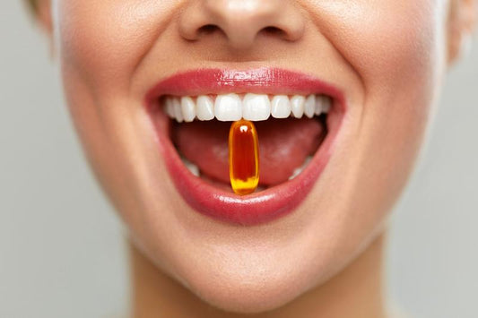 Woman smiling with vitamin between her teeth